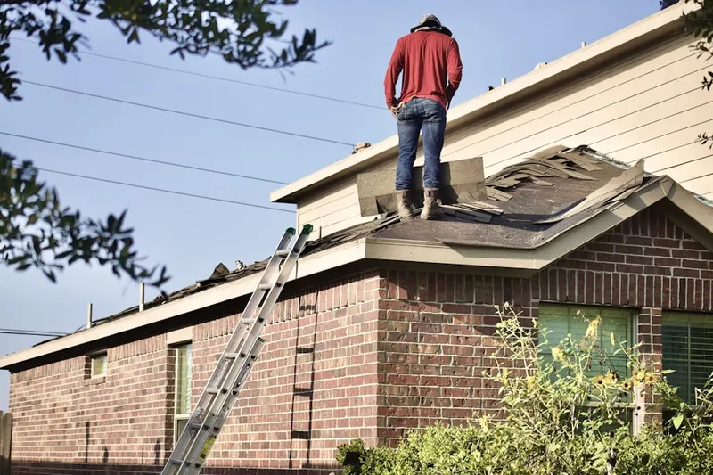 Professional roofer working on a residential roof in Tremont City